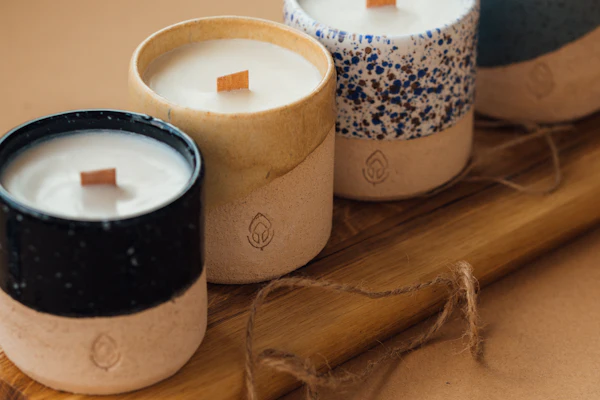 Velas artesanales en vasos de cerámica con mecha de madera